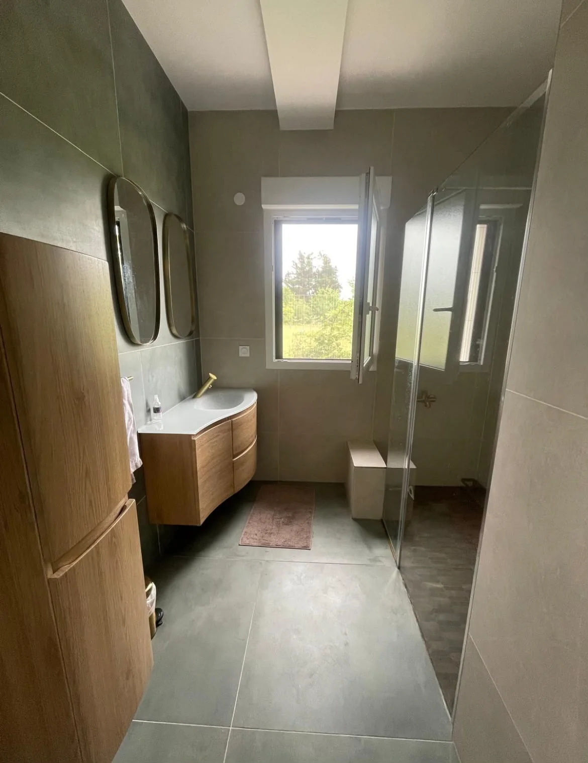 Salle de bain avec douche vitrée et meuble en bois